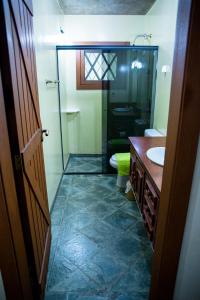 uma casa de banho com um lavatório, um WC e um espelho. em OM B&B + Spa em Viamão