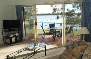 a living room with a couch and a table with a view at The Esplanade Riverview Holiday Apartments in Maroochydore