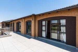 a building with glass doors and a patio at Alimama Spaces: Manson Mansion in Randjesfontein