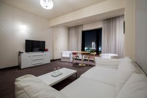 a living room filled with furniture and a tv at Orhideea Residence & Spa in Bucharest