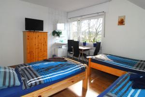 エシュヴァイラーにあるFerienwohnung Krings & Monteurwohnungenのベッドルーム1室(ベッド2台、テーブル、椅子付)