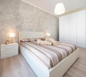 Un dormitorio con una gran cama blanca con dos lámparas. en Nice & Cozy apartment, en Venecia