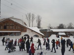 grupa ludzi stojących w śniegu blisko budynku w obiekcie Usadba Romashkovo Hotel w mieście Romashkovo