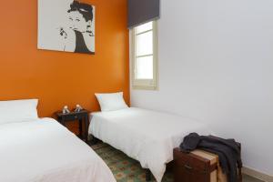 バルセロナにあるCasa Cosi - Mallorca 2のオレンジ色の壁の客室内のベッド2台