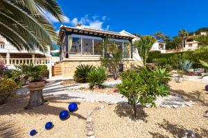 a house with blue balls on the ground in a yard at Villas Guzman - Kismet in Moraira
