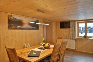 a dining room with a wooden table and chairs at Apartments Hänsler in Mellau