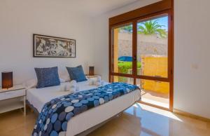 FanadixにあるVillas Guzman - Apartamento Jardines de Montemarのベッドルーム1室(ベッド1台、大きな窓付)