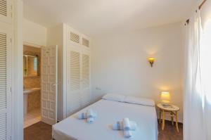 ベニッサにあるVillas Guzman - Helgaの白いベッドルーム(ベッド1台、バスルーム付)