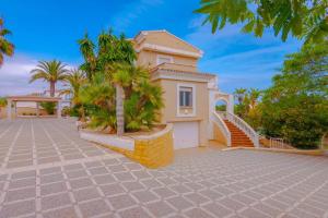 a house with palm trees in front of it at Villas Guzman - Ifach in Calpe