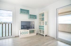 un salon blanc avec une télévision et une fenêtre dans l'établissement Villas Guzman - Apartamento LaJoya, à Calp