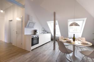 a white kitchen and dining room with a table and chairs at Flex Apartments Tour As Ljubljana in Ljubljana