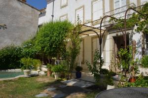a garden with trees and plants in front of a building at Le Patio Des Senteurs in Verzeille