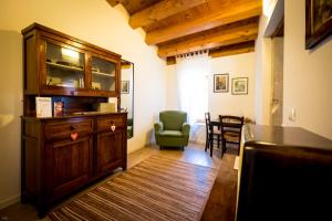 ein Wohnzimmer mit einem Holzschrank und einem grünen Stuhl in der Unterkunft Il Piccolo Principe B&B in Vittorio Veneto
