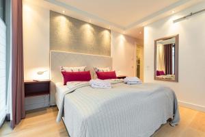 1 dormitorio con 1 cama blanca grande con almohadas rojas en Luxusferienwohnung Seebrise*****, en Binz