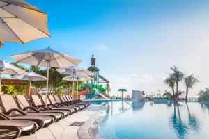 a swimming pool with lounge chairs and umbrellas at Sandos Playacar All Inclusive in Playa del Carmen