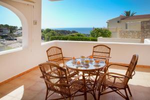 ベニッサにあるVillas Guzman - Magaliのテーブルと椅子、海の景色を望むバルコニー