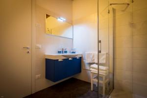 y baño con lavabo azul y ducha. en Il Piccolo Principe B&B, en Vittorio Veneto