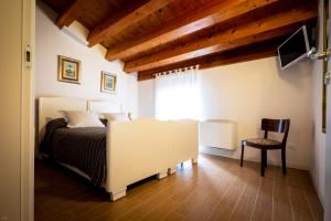 1 dormitorio con 1 cama y 1 silla en una habitación en Il Piccolo Principe B&B, en Vittorio Veneto