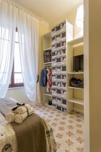 a bedroom with a bed with white curtains and shelves at Perle d'Ambra in Lucca