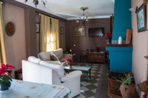 a living room with two white chairs and a table at Casa Rural Miradas De Aracena in Aracena