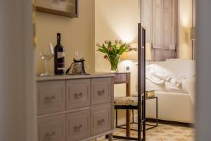 een slaapkamer met een bed en een tafel met een vaas met bloemen bij Perle d'Ambra in Lucca