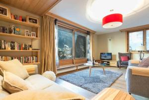 Chamois Apartment- Chamonix All Year في شامونيه مون بلان: غرفة معيشة مع أريكة وطاولة