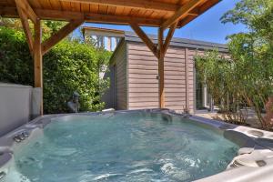 a hot tub in the backyard of a house at Les Carmes and spa in Le Thor