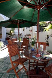 大叻的住宿－杜拉克達拉特別墅酒店，一张带椅子的木桌和一把绿色雨伞