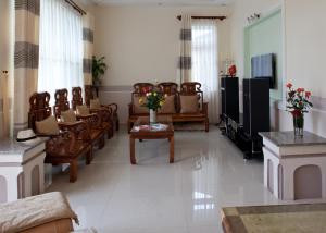 大叻的住宿－杜拉克達拉特別墅酒店，客厅配有一束椅子和一台电视