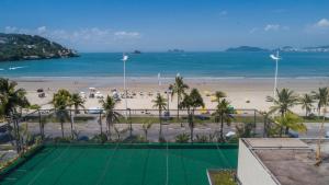 um campo de ténis em frente a uma praia em Pousada Stand Up! Guarujá no Guarujá