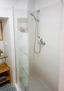 La salle de bains est pourvue d'une douche avec une porte en verre. dans l'établissement * 5 Star Apartment in Historic District * walk 2 Alfama!, à Lisbonne
