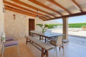 a dining room with a table and chairs on a patio at Can Venzala in Pollença