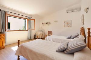 a bedroom with two beds and a window at Can Venzala in Pollença +16 photos