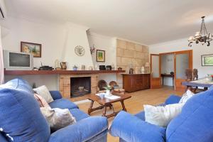 a living room with blue couches and a fireplace at Can Venzala in Pollença