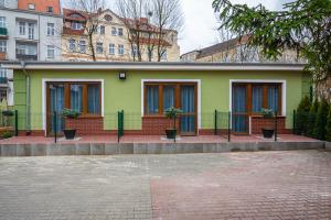 ein grünes Haus mit Pflanzen davor in der Unterkunft Hotel Topaz Poznań Centrum in Posen