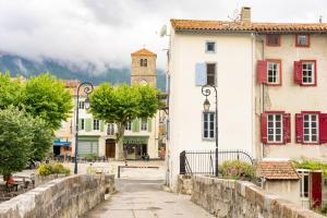 una calle en una ciudad con una torre de reloj en Logis Hôtel Cartier, en Quillan