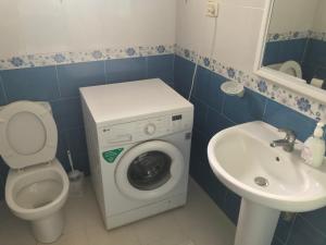 a bathroom with a washing machine and a sink at Maison dhiefa avec piscine in Temlale