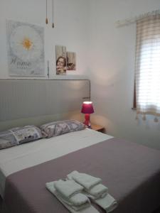 een slaapkamer met een bed met handdoeken erop bij Villetta La Ginestra in Stintino +40 foto's