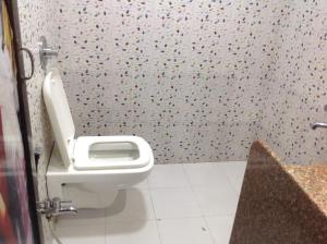 a bathroom with a white toilet in a room at Spring Resort & lodging in Mumbai