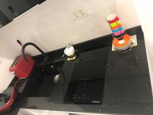 a kitchen with a black counter top with a red appliance at VICTORIA LUXURY APARTMENT in Bucharest +26 photos