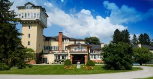 a large building with a tower on top of a yard at Briars Resort and Spa in Georgina