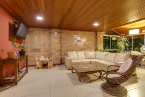 a living room with a couch and a tv at Pousada Ilha Faceira in Florianópolis