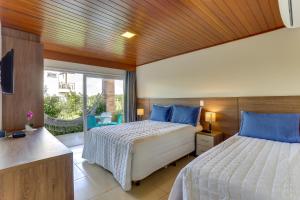 a bedroom with two beds and a large window at Pousada Ilha Faceira in Florianópolis +37 photos
