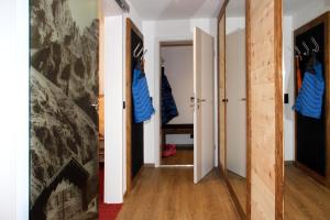 einen Flur mit Tür und Spiegel in einem Zimmer in der Unterkunft Gästehaus Sinz in Oberstdorf