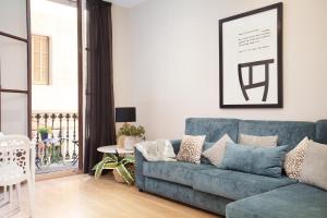 a living room with a blue couch and a table at Easysleep Borne in Barcelona