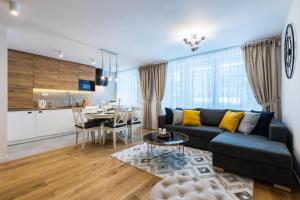 a living room with a couch and a table and a kitchen at Apartament Przy Krupówkach Odkryj Zakopane in Zakopane