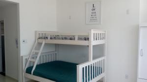 a white bunk bed in a room with a ladder at AUDAX MARAVILHA in São Vicente