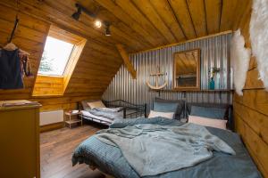 ein Schlafzimmer mit einem Bett in einer Holzhütte in der Unterkunft Apartmany Calma in Liptovský Mikuláš