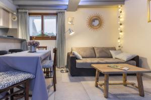 a living room with a couch and a table at Aux 3 nids fleuris in Irreville +18 photos