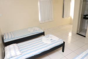 2 Einzelbetten in einem Zimmer mit Fenster in der Unterkunft Hotel Piramide Pernambués (Adults Only) in Salvador